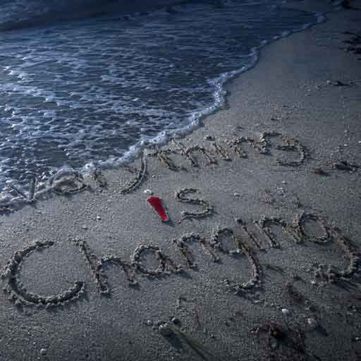 Everything Is Changing cover art with the title written in wet sand as the tide begins to wash it away