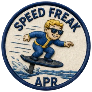 Verdant Ride Speed Freak badge for April — embroidered navy-ringed patch showing a rider crouched low on an eFoil with spray and speed lines behind, and APR on the banner below