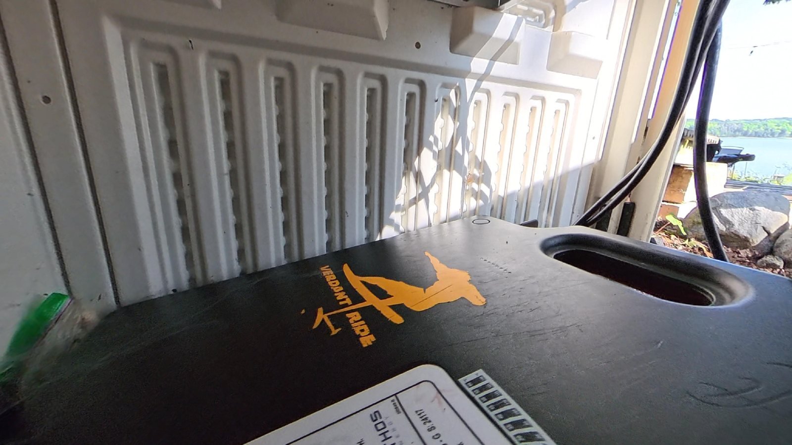 eFoil battery case marked with an orange Verdant Ride logo sticker beside its high voltage warning label