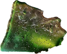 A weathered piece of green sea glass, frosted and pitted from the surf
